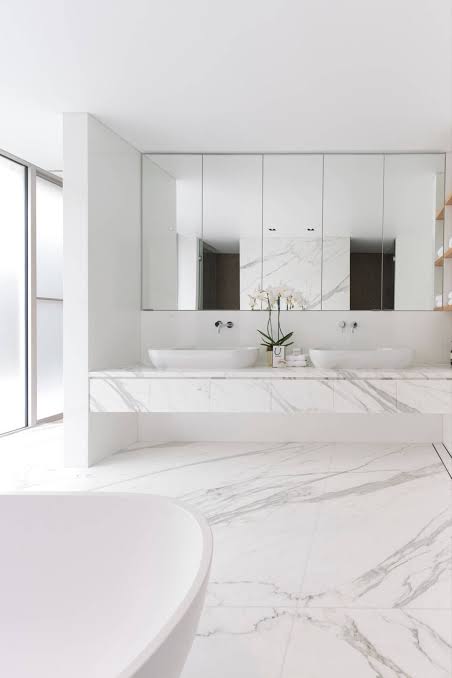 White marble bathroom tiles with a double sink vanity and freestanding tub