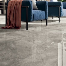 Grey marble effect porcelain floor tiles in a modern living room with a blue velvet armchair