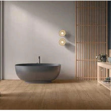 Wood effect porcelain floor tiles in a modern bathroom with a grey freestanding bathtub